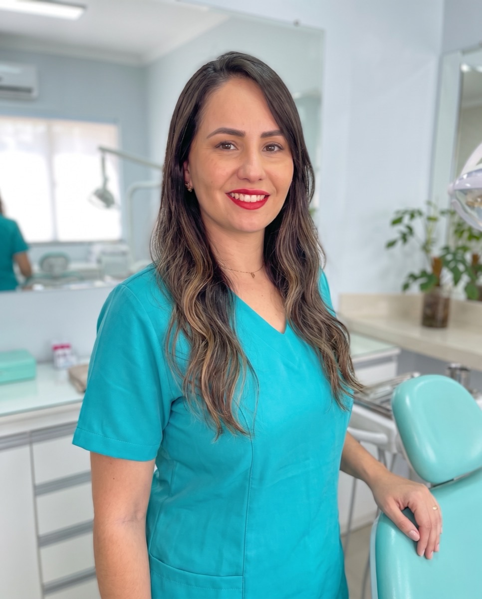 Dra. Romina Petrucci de uniforme turquesa no consultório